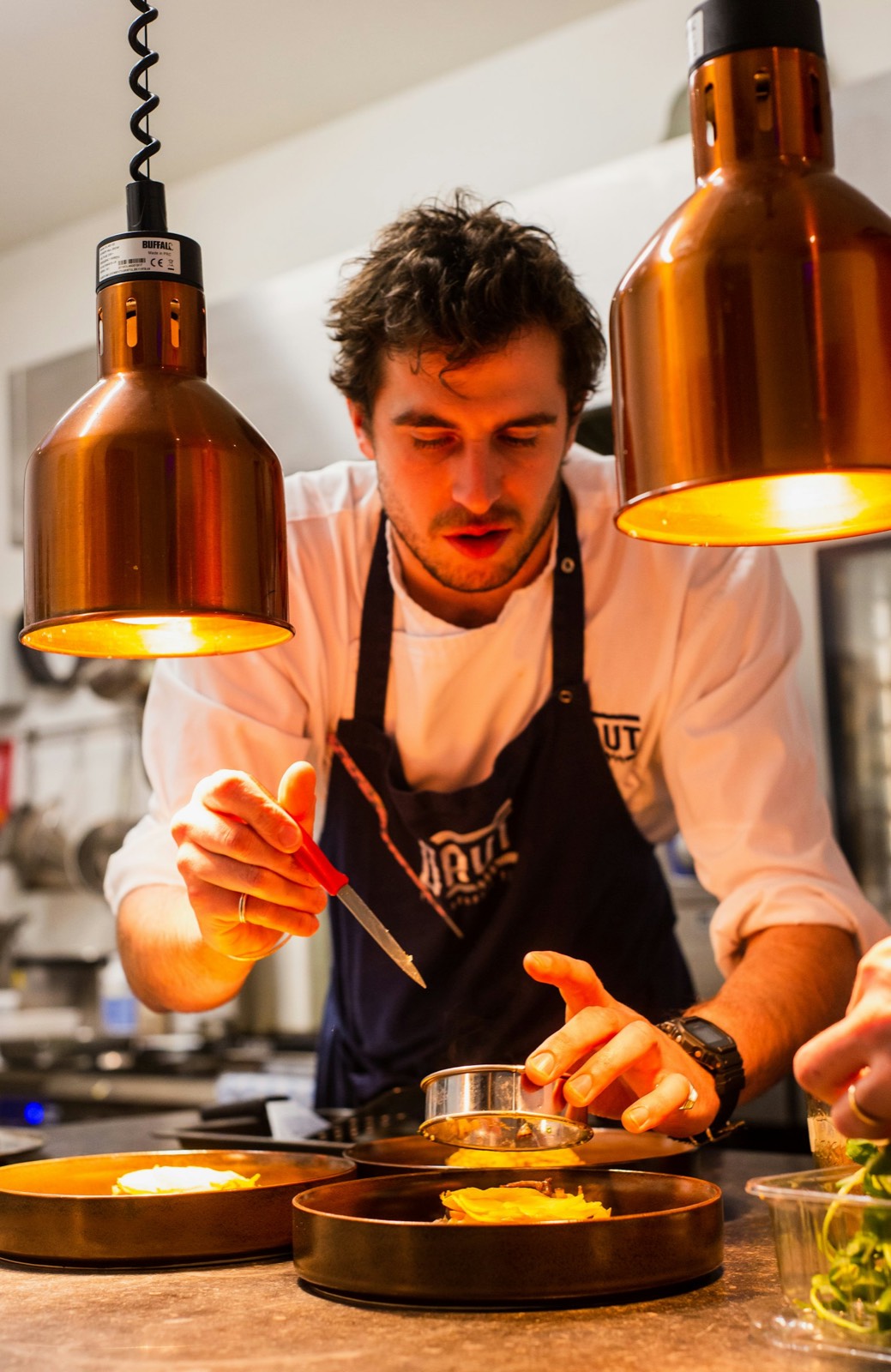 Chefe de cozinha a preparar pratos numa cozinha profissional